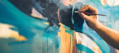Hands of Young painter working on his art inside his studio.
